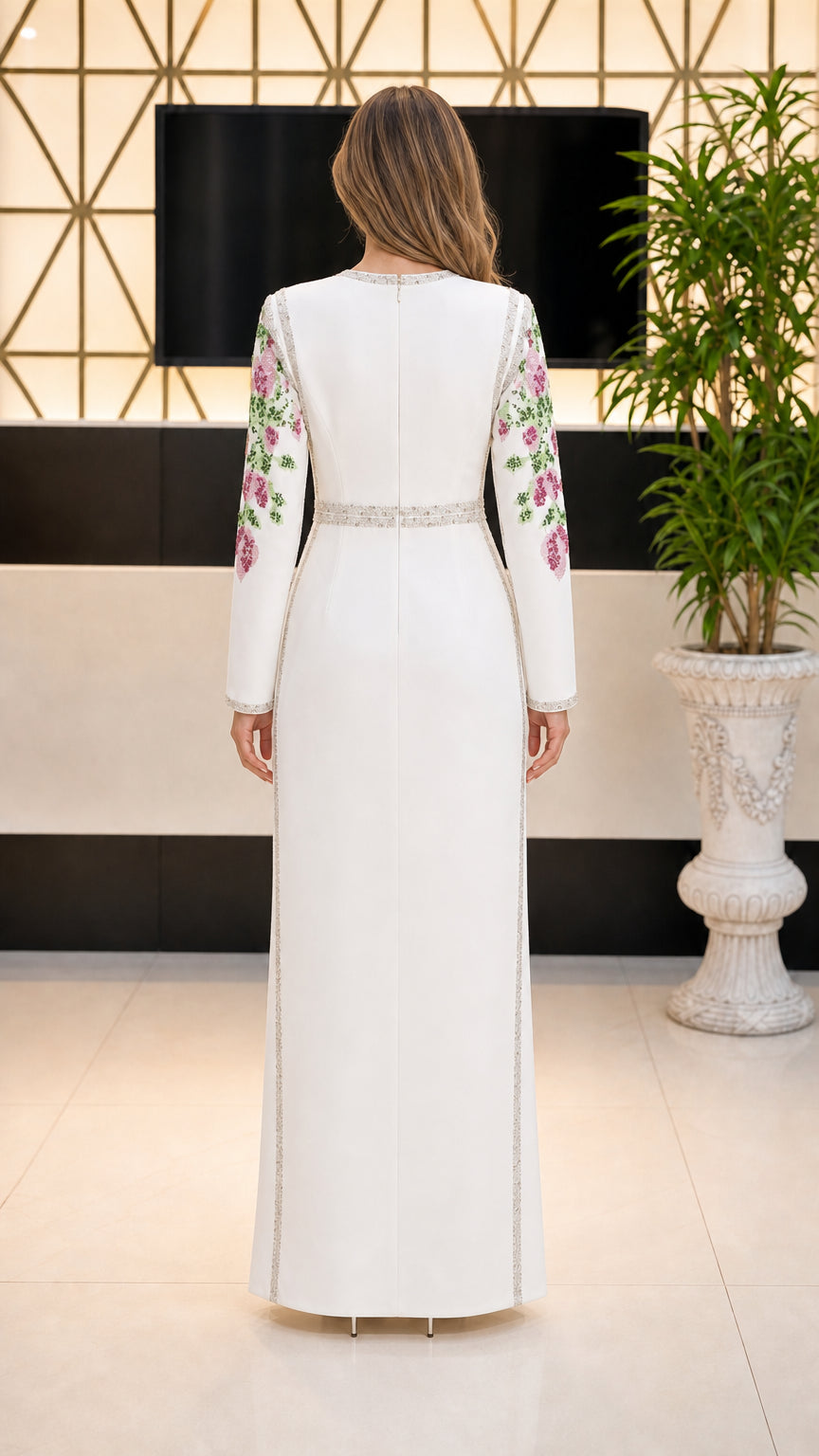Back view of white long sleeve column maxi dress with embroidered sleeves and waist detail