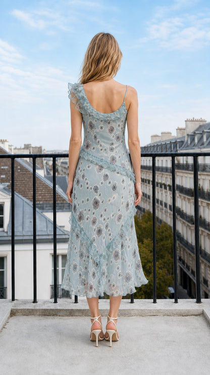 Back view of model showing scoop back design on dusty blue floral midi dress