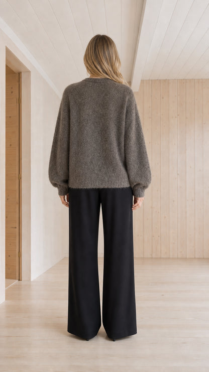 Back view of model wearing charcoal grey crewneck knit cardigan