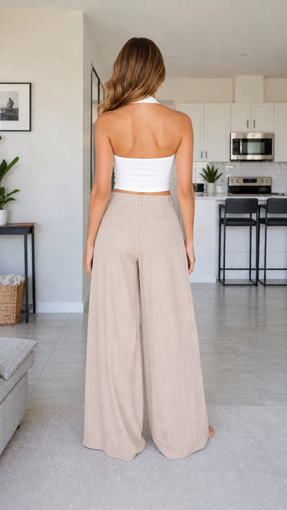 Back view of model wearing beige high waisted wide leg trousers