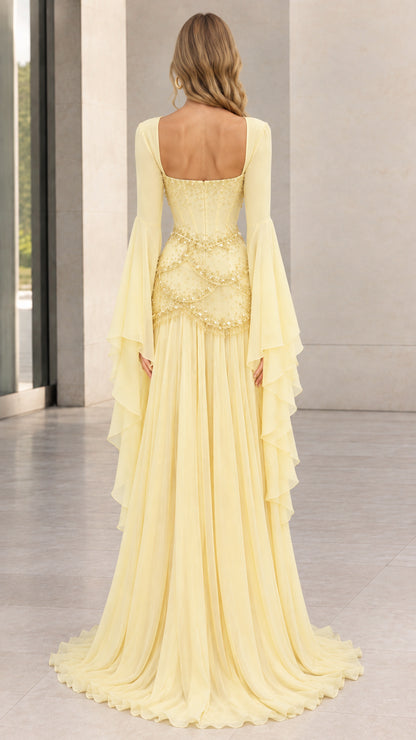 Back view of pastel yellow corset evening gown showing open square back and flowing skirt
