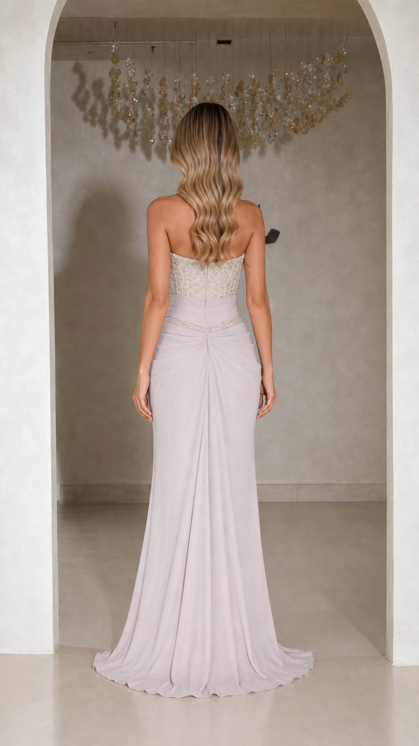 Back view of model wearing silver lilac formal gown with sweep train
