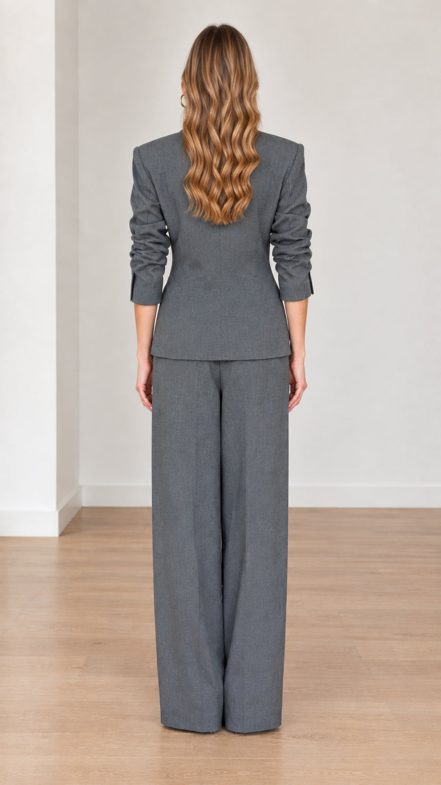 Back view of woman wearing Charcoal Grey tailored blazer and wide-leg pants