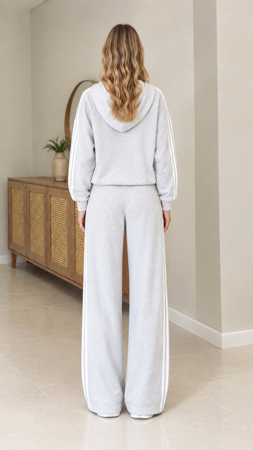 Back view of model wearing Heather Grey hooded sweatshirt and matching pants
