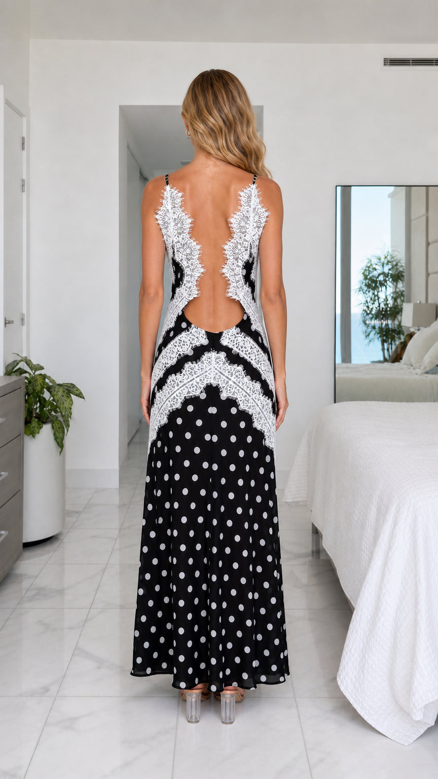 Back view of black polka dot maxi dress showing open back with delicate lace border