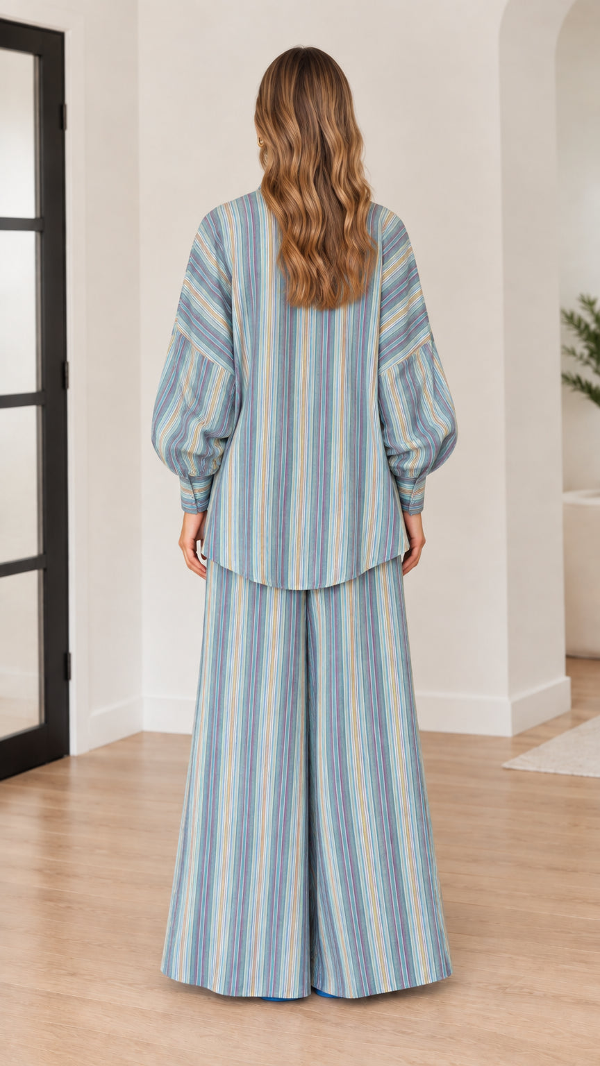 Back view of woman wearing blue striped long sleeve tunic and wide leg trousers