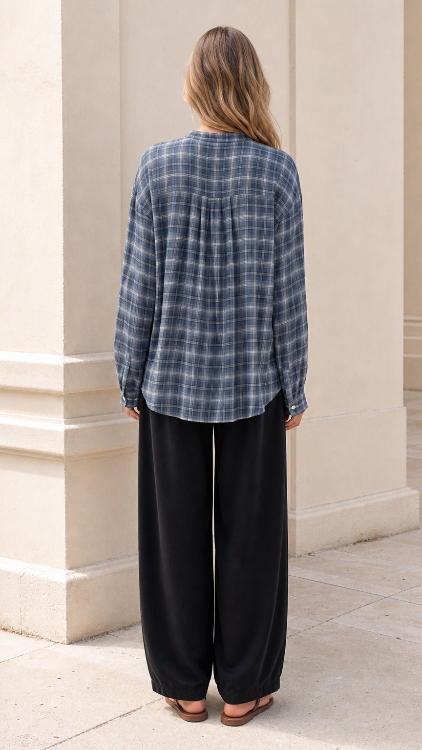 Back view of model showing the back yoke gathering on slate blue plaid shirt