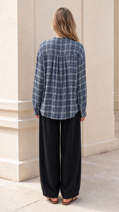Back view of model showing the back yoke gathering on slate blue plaid shirt