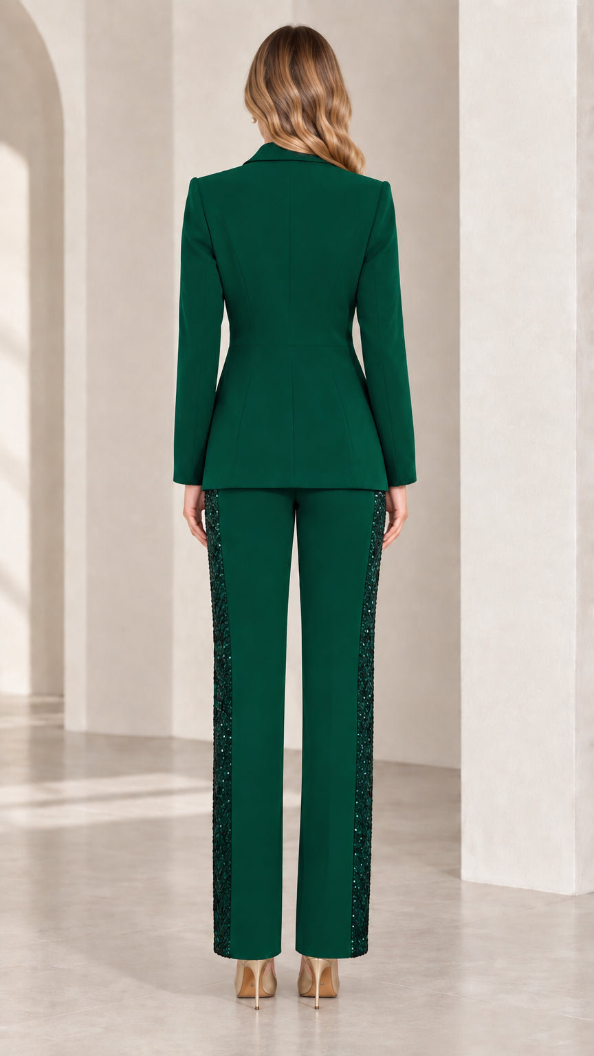 Back view of woman wearing tailored emerald green blazer and straight-leg trousers