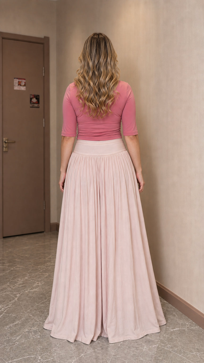 Back view of woman wearing pink top and wide leg pants outfit
