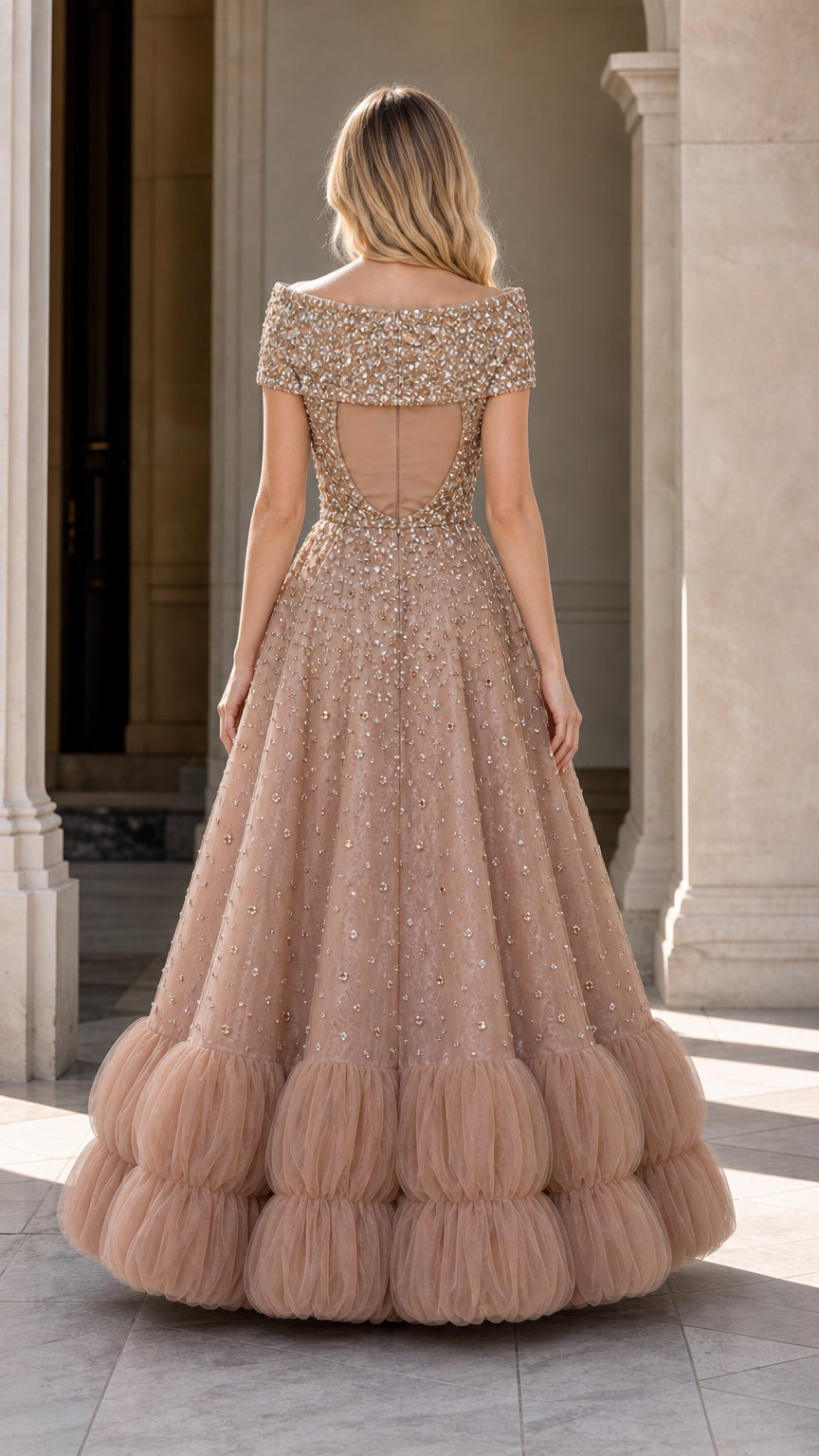 Back view of champagne formal gown showing open back cutout and tiered tulle hem