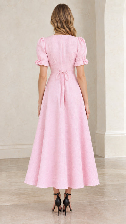 Back view of pastel pink textured dress highlighting tie back waist and zipper