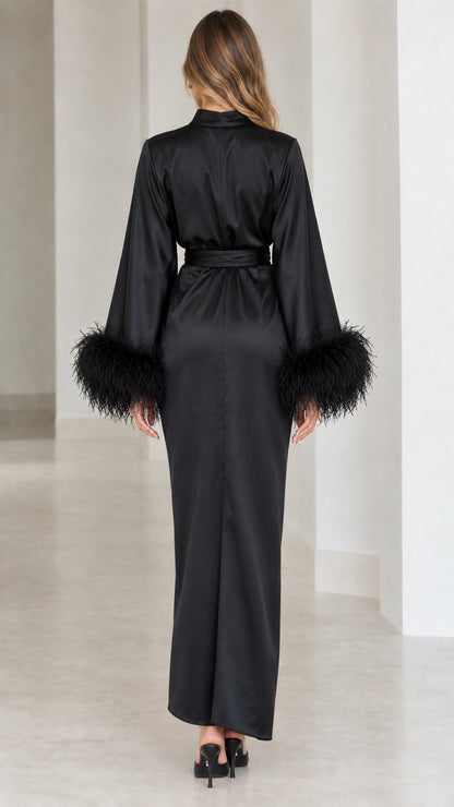 Back view of model wearing black satin mock neck gown with draped silhouette