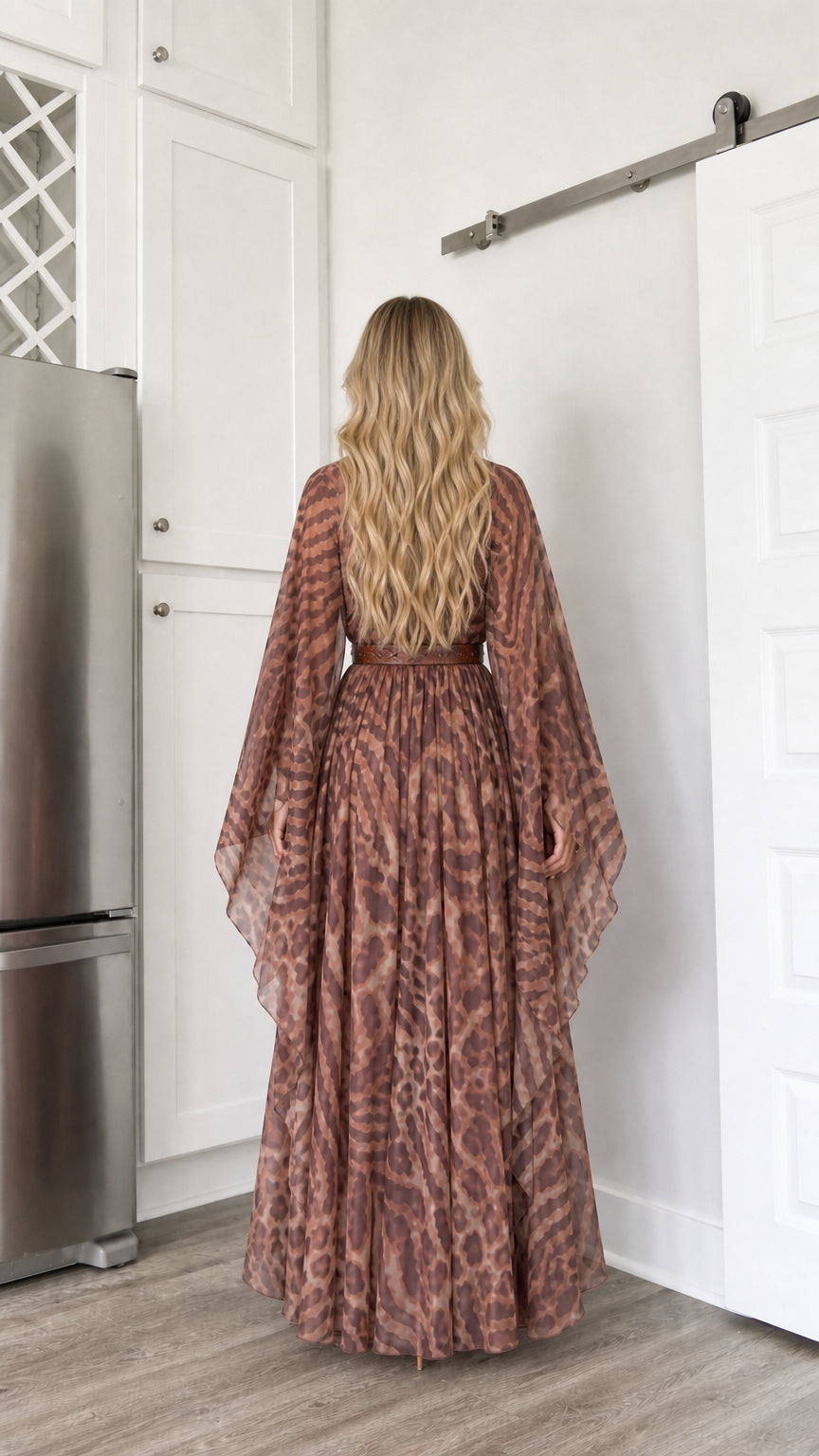 Back view of woman showing the gathered back and cape sleeves of brown maxi dress