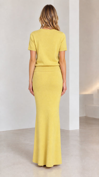 Back view of model wearing yellow short sleeve top and column maxi skirt