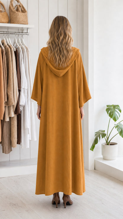 Back view of woman in mustard hooded maxi dress