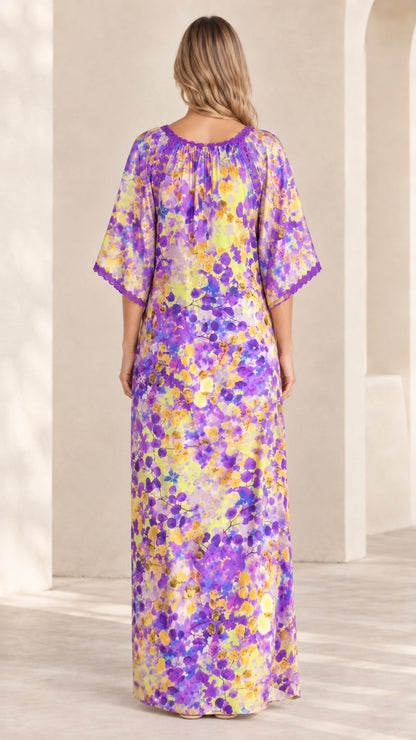 Back view of model in purple floral kaftan dress highlighting crochet neckline detail