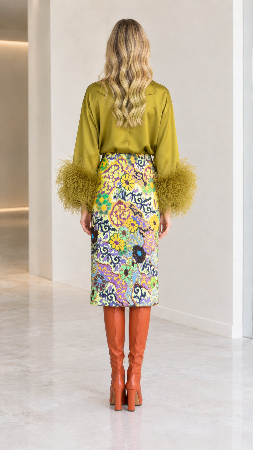 Back view of olive green satin long-sleeve blouse and printed midi skirt
