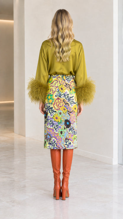 Back view of olive green satin long-sleeve blouse and printed midi skirt
