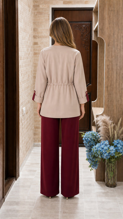 Back view of model showing cinched drawstring waist and fluid burgundy pants
