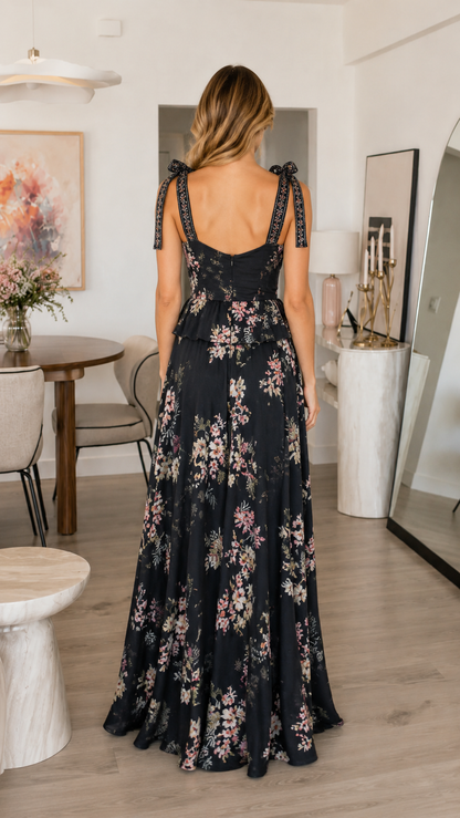 Back view of black floral maxi dress with tie shoulders and full-length drape