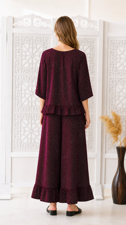 Back view of woman modeling burgundy polka dot two-piece co-ord set