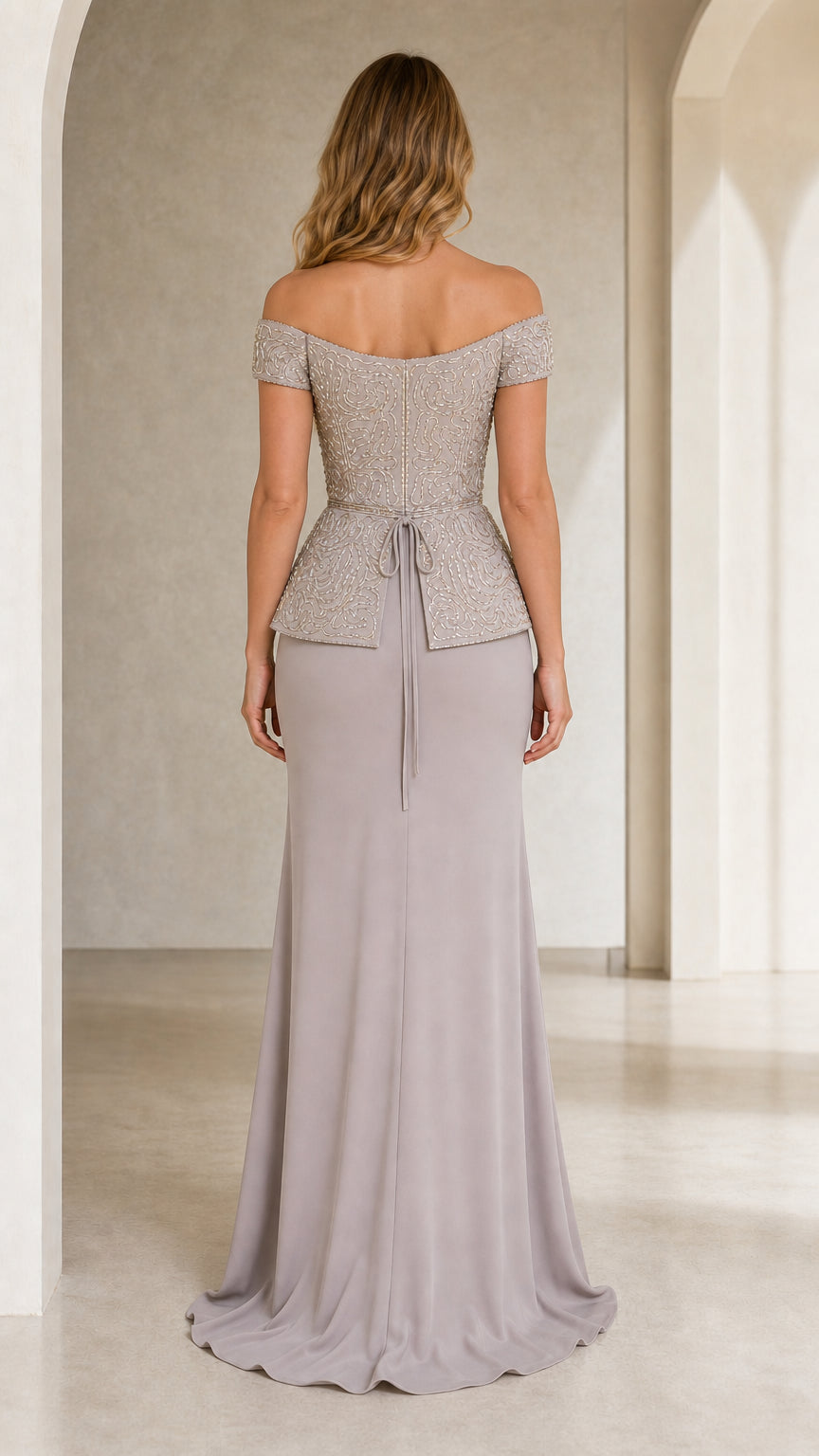 Back view of woman in silver grey beaded formal evening dress showing back waist tie