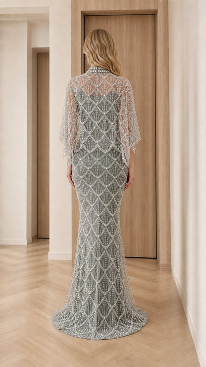 Back view of model in sage green pearl embellished capelet maxi gown