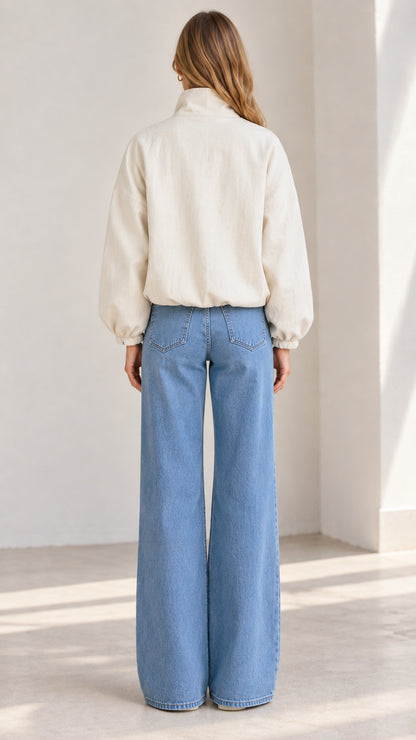 Back view of the woman wearing the relaxed beige waist-length bomber jacket