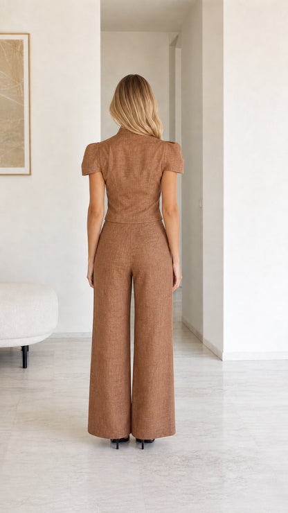 Back view of model showcasing wide leg trousers and structured top