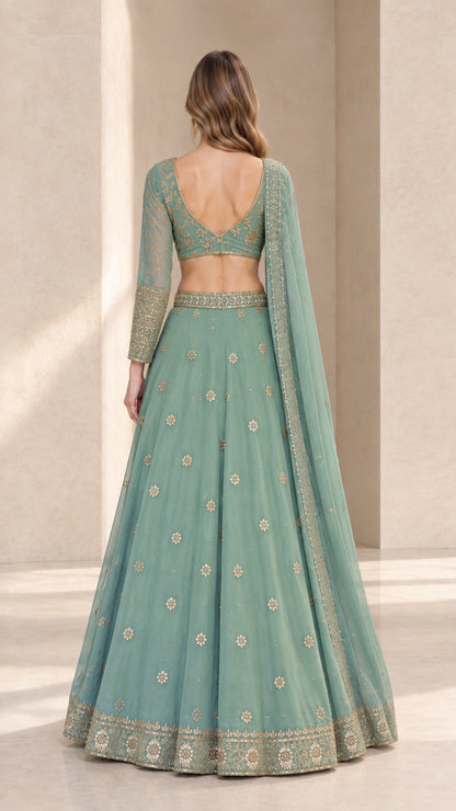 Back view of woman wearing sage green lehenga choli showing V-back design