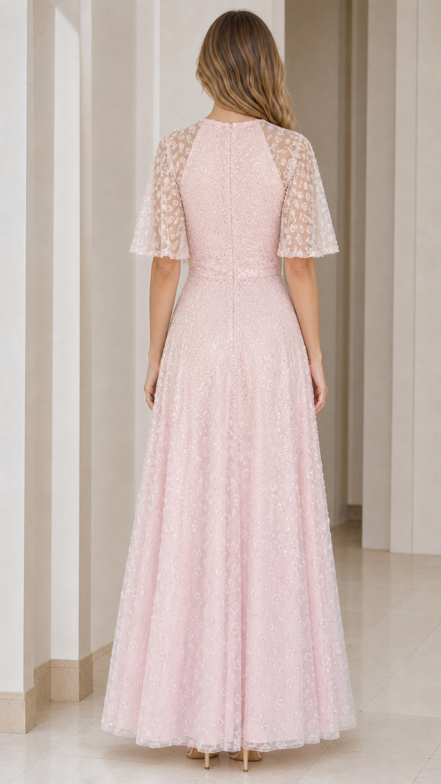 Back view of woman wearing blush pink flutter sleeve formal gown