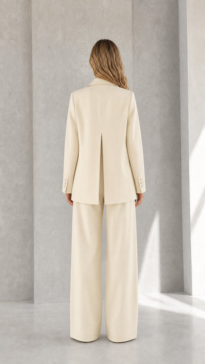 Back view of woman wearing cream blazer and wide-leg pants showing inverted back vent