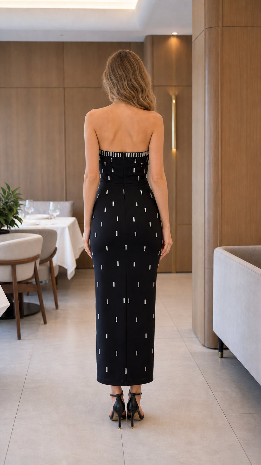 Model wearing black strapless column midi dress back view