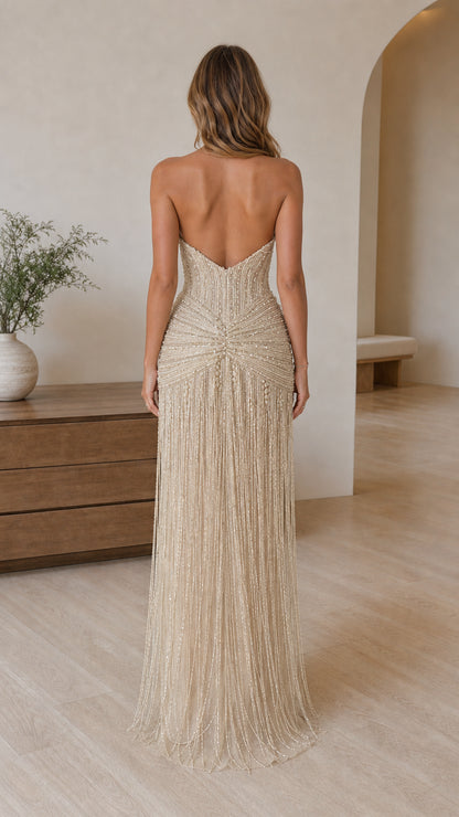Back view of champagne strapless gown showing low-cut back and long fringe