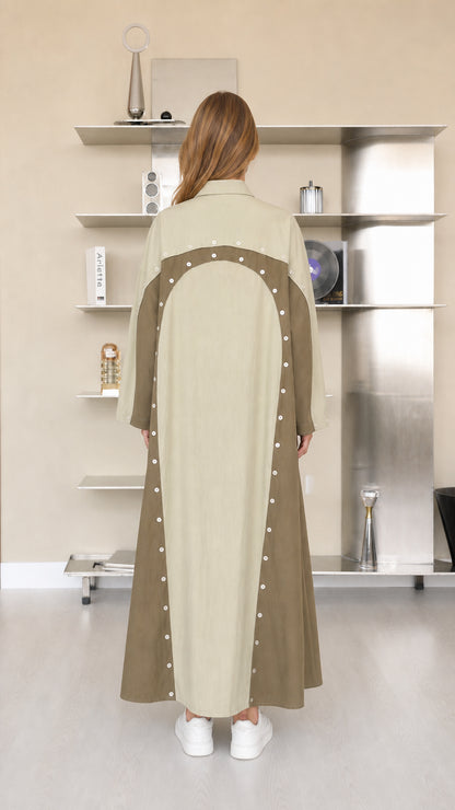 Back view of sage green two-tone maxi dress showing curved panel and button accents