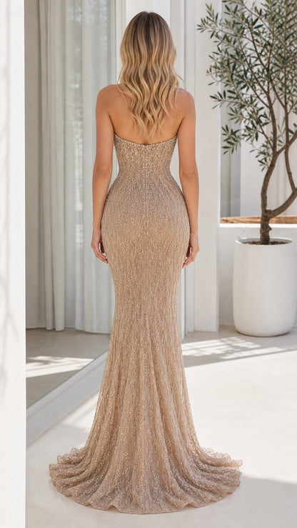 Back view of woman wearing champagne strapless floor-length evening gown