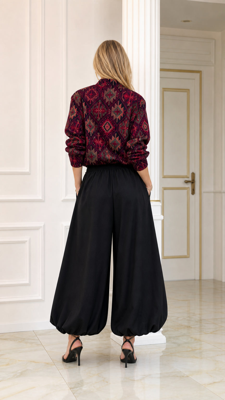 Back view of burgundy ethnic pattern long-sleeve blouse and black wide balloon trousers