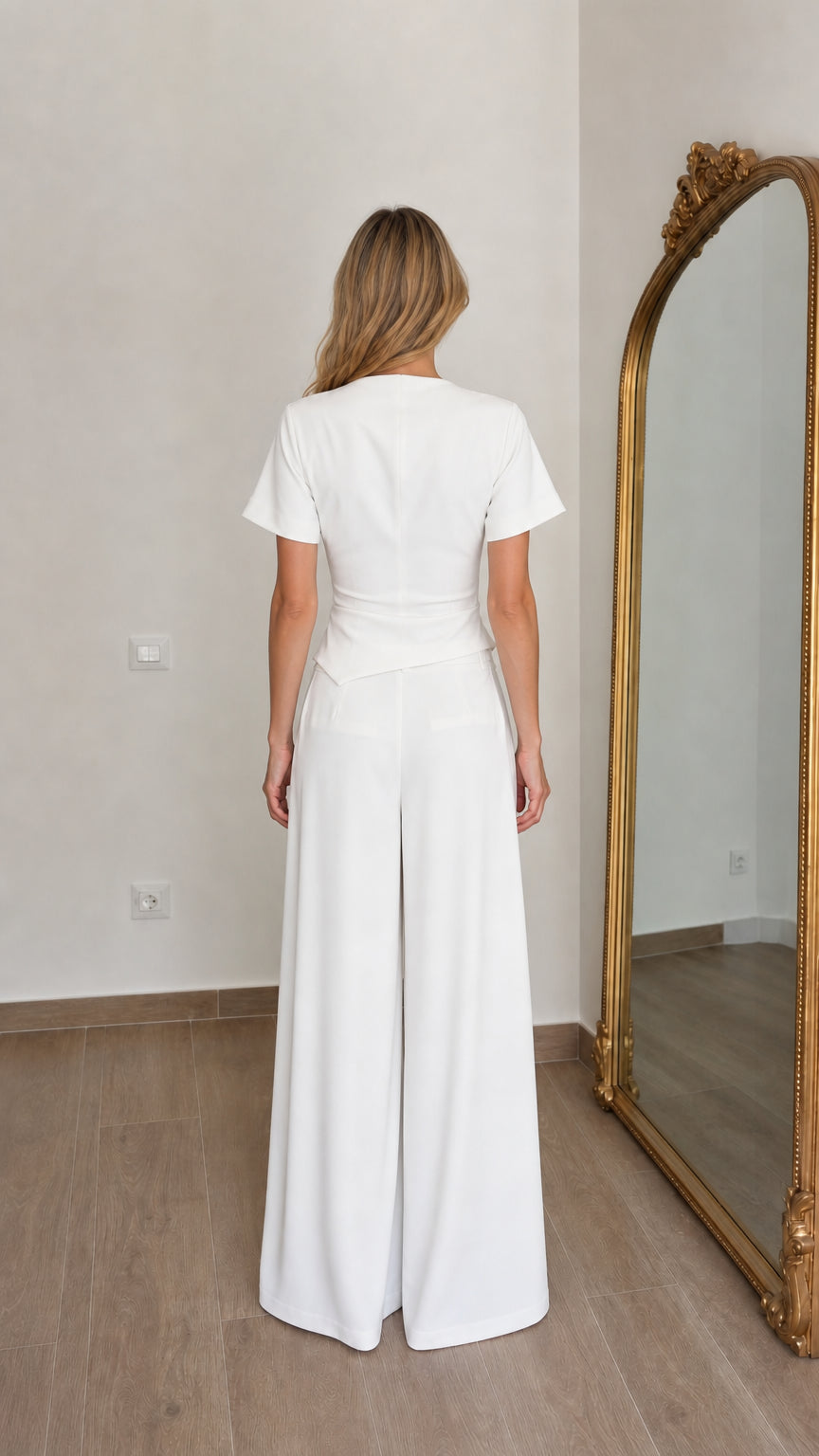 Back view of woman wearing white two piece trouser set