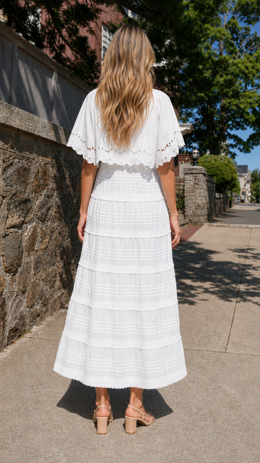 Back view of woman wearing white cape sleeve maxi dress
