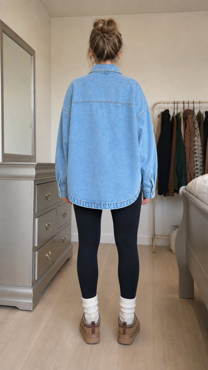 Back view of model showing curved hem of light blue denim shacket