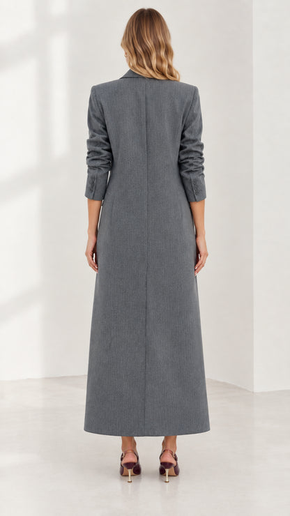 Back view of woman wearing structured grey maxi coat showing long clean hemline