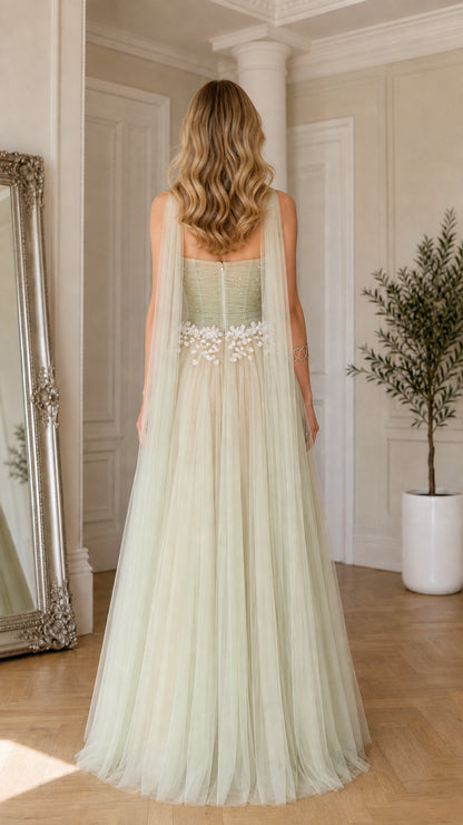 Back view of sage green tulle evening gown highlighting back neckline and cascading shoulder streamers