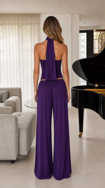 Back view of women's purple halter top showing neck drape and wide-leg pants