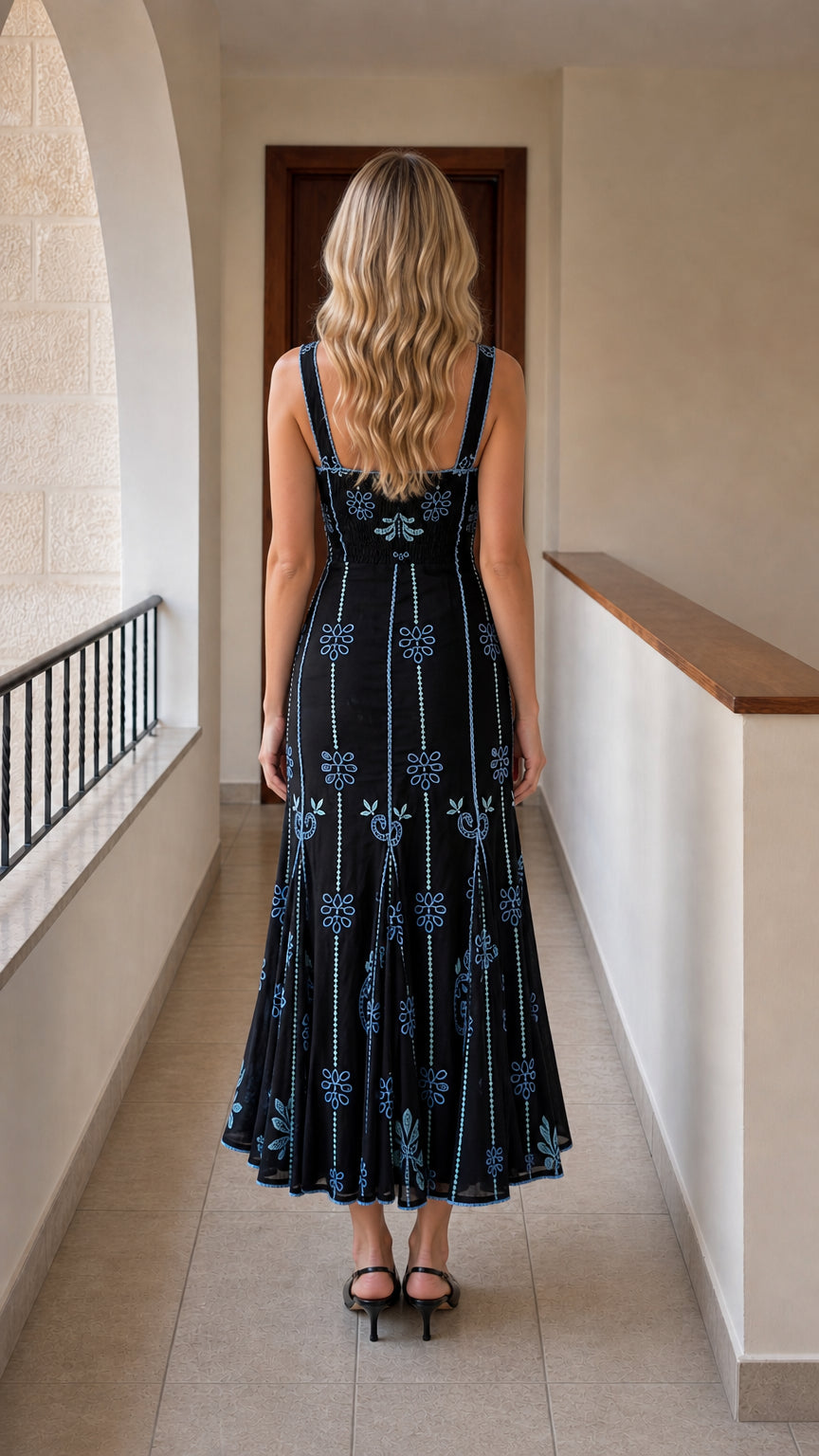 Back view of black embroidered midi dress showing straps and hem
