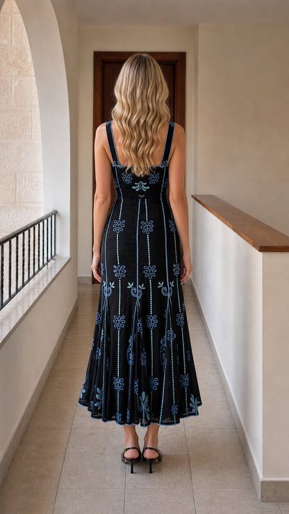 Back view of black embroidered midi dress showing straps and hem
