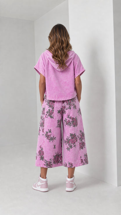 Back view of woman wearing washed pink hooded shirt and floral wide-leg pants set