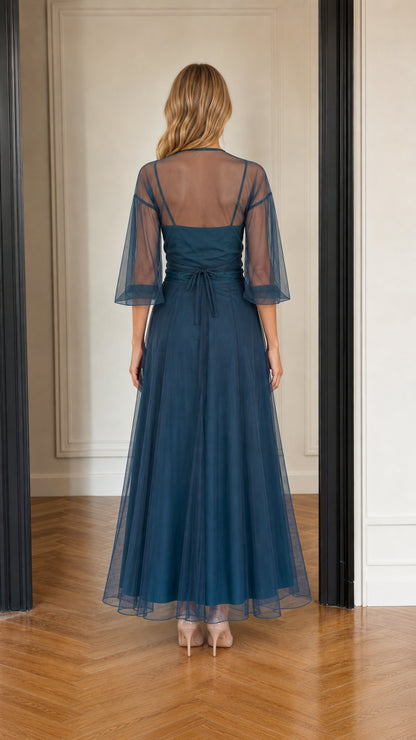 Back view of teal blue A-line tulle maxi dress showing sheer back overlay
