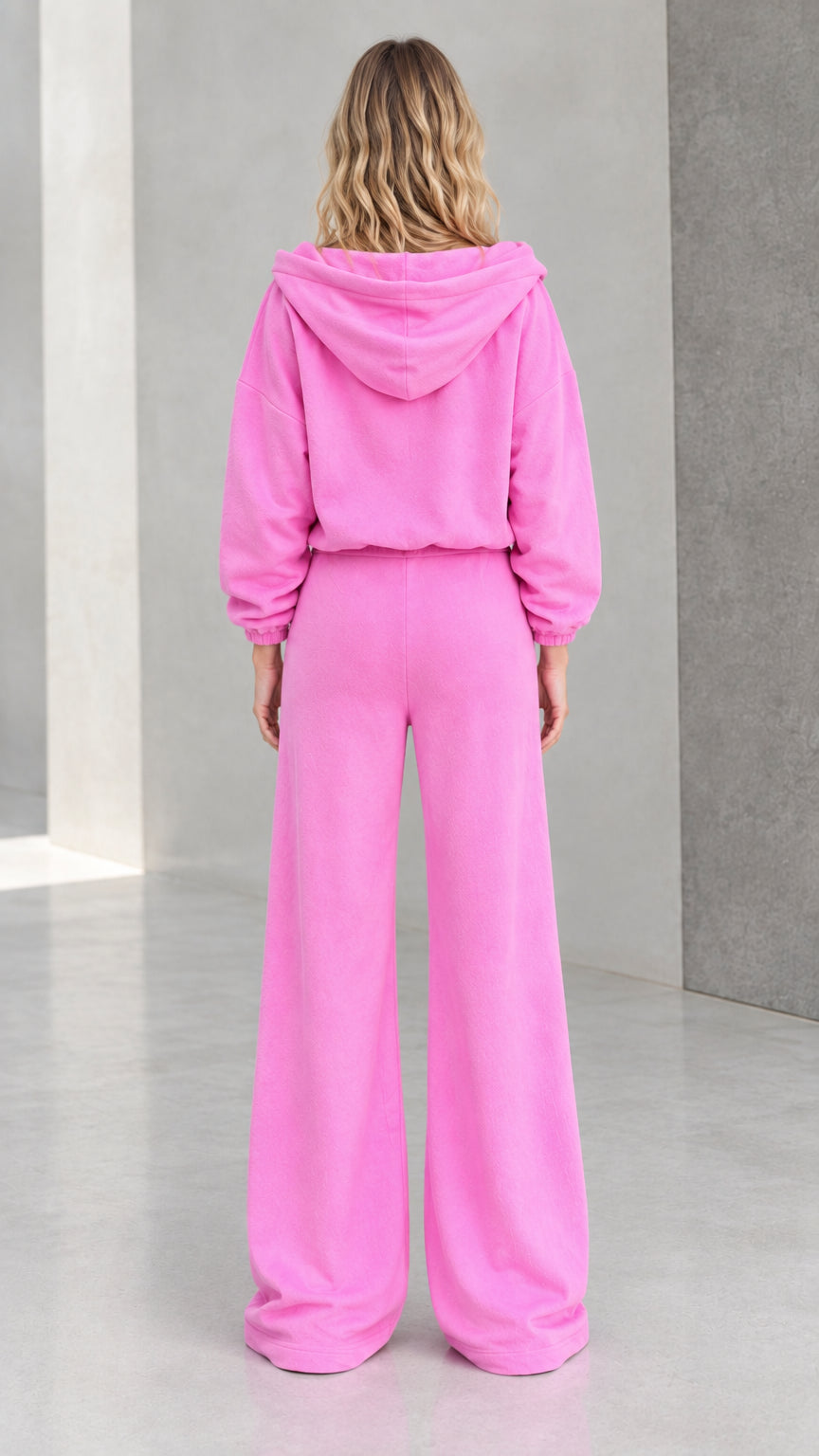 Back view of model wearing pink hooded sweatshirt and wide leg pants