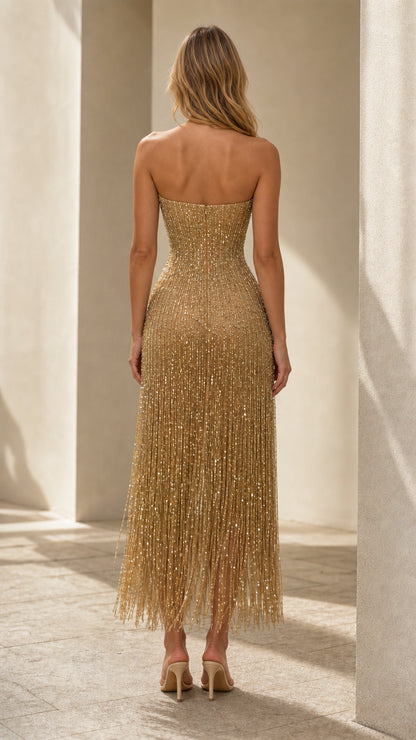 Back view of model in gold strapless sequin fringe midi dress